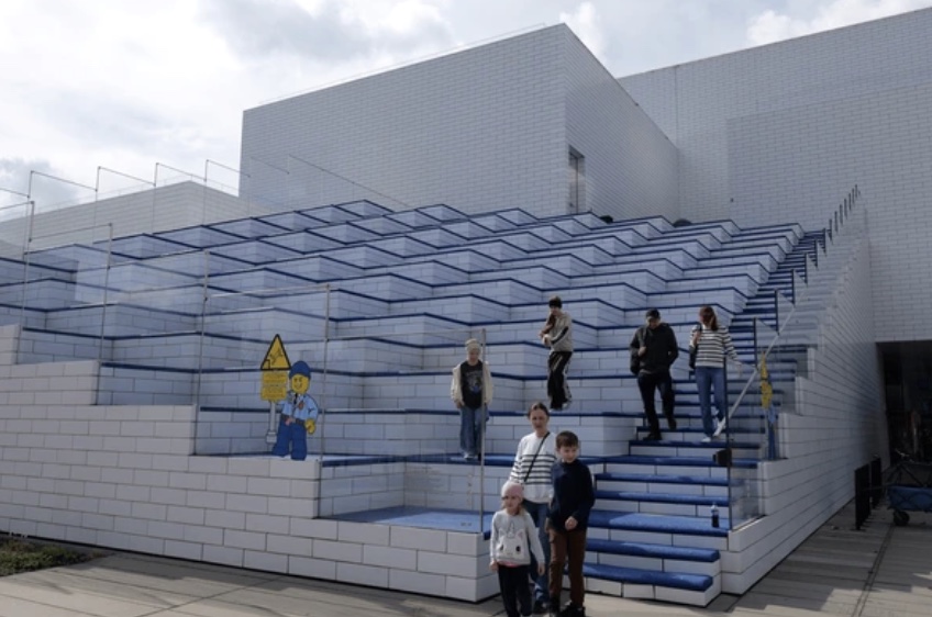 Fachada de bloques modulares apilados de la LEGO House — metáfora de la arquitectura MACH