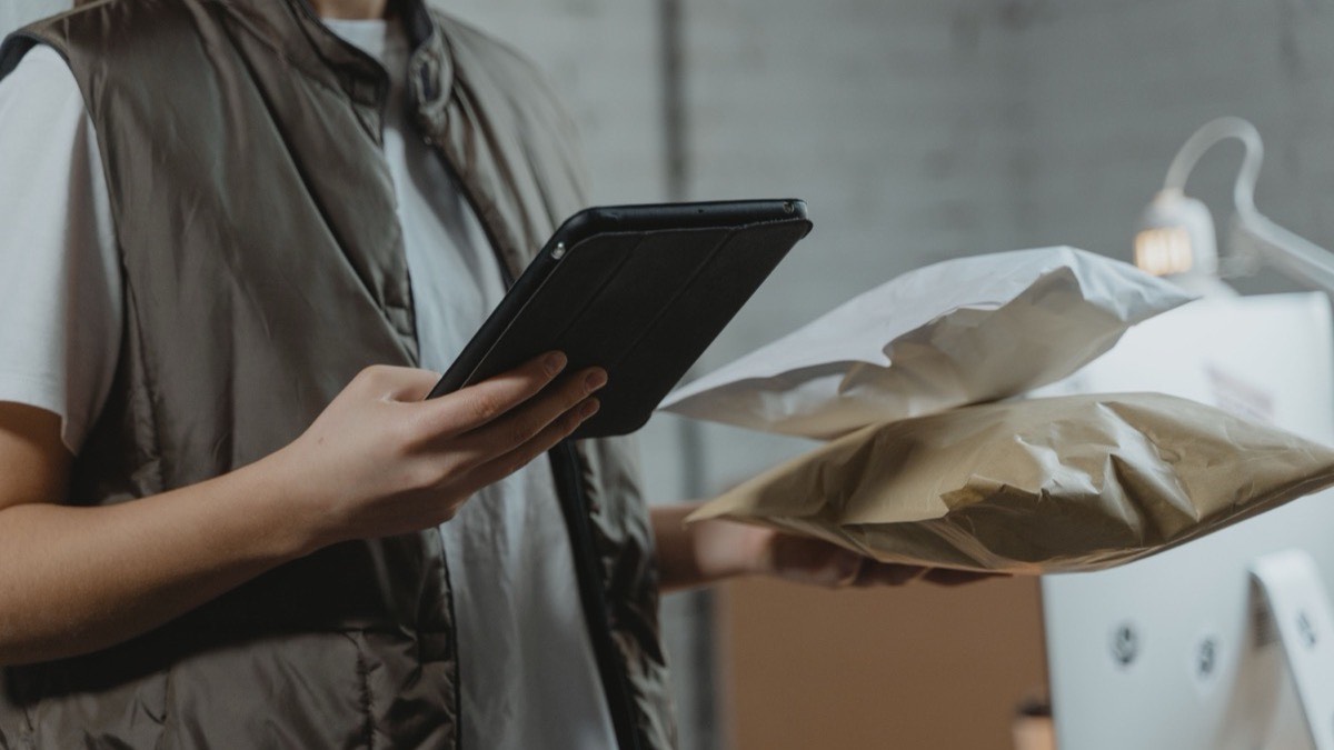 Operadora de almacén con tablet revisa un pedido empaquetado — PunchOut y procurement digital en eCommerce B2B